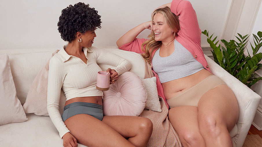 two models on a couch wearing period underwear